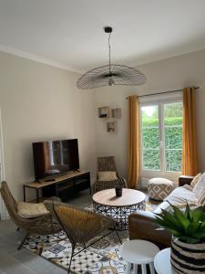 sala de estar con sofá y mesa en Maison, cottage, en Choisy-au-Bac