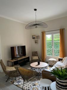 a living room with a couch and a table at Maison, cottage in Choisy-au-Bac