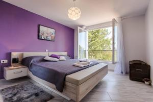 Un dormitorio púrpura con una cama grande y una ventana en Modern villa with pool, whirpool in quiet area - by Traveler tourist agency Krk ID 2180, en Gostinjac 34 fotos más