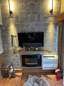 sala de estar con chimenea y TV en Pirin Golf&Spa Apartment 42, en Razlog