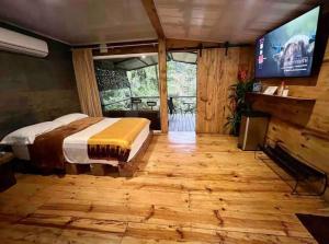 een slaapkamer met een bed en een flatscreen-tv bij Sweet Jungle in Quesada