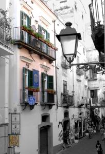 a building with balconies and a street with a street light at ApartHotel Antica Repubblica in Amalfi center at 100mt from the sea with payment parking in Amalfi