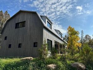 a house with a gray barn at Villa Les Flots: Breathtaking view of St Lawrence in La Malbaie