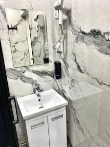 a white bathroom with a sink and a mirror at Апартаменты аэропорт 1 in (( Turksib ))