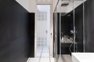 Baño negro con lavabo y espejo en Bocà Home, en Salerno
