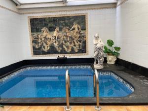 a swimming pool in a room with a painting on the wall at SPA Versalles in Las Lagunas