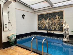 a swimming pool with a painting on the wall at SPA Versalles in Las Lagunas