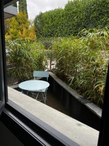 una mesa y una silla sentadas fuera de una ventana en Superbe appartement entre lac et montagne., en Veyrier-du-Lac