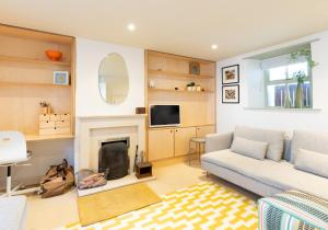 a living room with a couch and a fireplace at London House, a stylish family home for 6. in Newport Pembrokeshire
