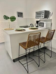a kitchen with a counter with two chairs and a microwave at Studio Palermo Hollywood location! in Buenos Aires