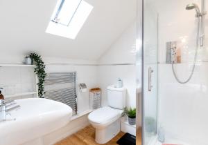a white bathroom with a toilet and a shower at London House, a stylish family home for 6. in Newport Pembrokeshire +28 photos