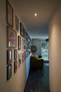 a hallway with a living room with pictures on the wall at The Green Garden Spa & Serenity in Mittelhausbergen