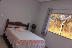 Rancho Pôr do Sol في بيوي: غرفة نوم بسرير ونافذة كبيرة