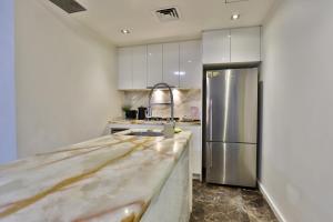 a kitchen with a marble counter top and a refrigerator at CBD Harbour Retreat - Lovely 2BR Home in Sydney