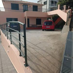 um carro vermelho estacionado num parque de estacionamento ao lado de uma casa em Casa Bela Vista Studio 2 em Ribeira Brava