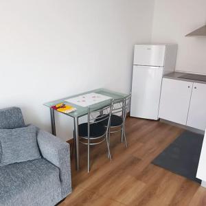 uma sala de estar com uma mesa, um sofá e um frigorífico em Casa Bela Vista Studio 2 em Ribeira Brava