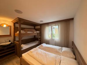 1 Schlafzimmer mit 2 Etagenbetten und einem Waschbecken in der Unterkunft Luxury Apartment Davos in Davos