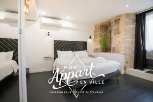 Una habitación con una cama con un cartel que lee mamá agente en suite en L' échafaud - Apparts de standing - Centre historique, en Périgueux