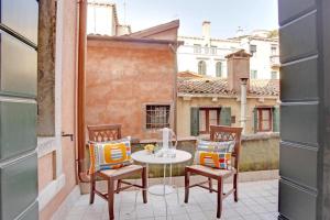 eine Terrasse mit einem Tisch und Stühlen auf dem Balkon in der Unterkunft Grimaldi Apartments Cannaregio in Venedig