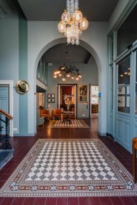 a living room with a checkered floor and a chandelier at Hotel Mercier in Amsterdam