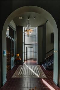 pasillo con lámpara de araña y suelo de baldosa en Hotel Mercier, en Ámsterdam