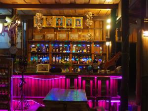 eine Bar mit lila Lichtern in einem Zimmer in der Unterkunft Coconutbeach Bungalows Party Hostel in Koh Rong