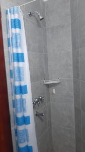 ducha con cortina azul y blanca en Estudio amoblado con cama individual y baño privado en Rosario