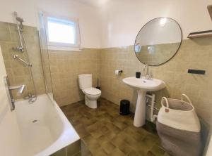 ein Badezimmer mit einem Waschbecken, einem WC und einem Spiegel in der Unterkunft Entre terre et mer 