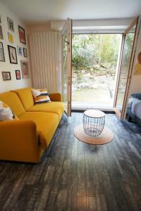 a living room with a yellow couch and a table at The Green Garden Spa & Serenity in Mittelhausbergen