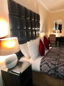 a hotel room with a bed with a large headboard at Kings Park Hotel in Glasgow