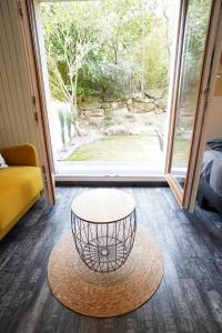 a room with a coffee table and a large window at The Green Garden Spa & Serenity in Mittelhausbergen