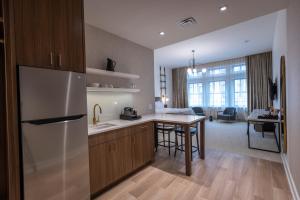 a kitchen with a refrigerator and a table in a room at Hotel Covington Cincinnati Riverfront in Covington