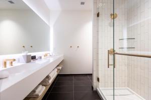 a bathroom with two sinks and a shower at Hotel Covington Cincinnati Riverfront in Covington