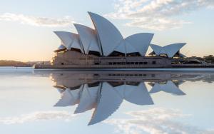 a sydney opera house with its reflection in the water at CBD Harbour Retreat - Lovely 2BR Home in Sydney