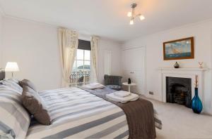 1 dormitorio con 1 cama grande y chimenea en Cliffhanger 18 Castle Road en Cowes