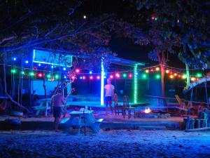 a group of people standing outside of a building with lights at Coconutbeach Bungalows Party Hostel in Koh Rong Island