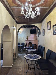 un restaurante con mesas y sillas y una lámpara de araña en Dar Bargach, en Tánger