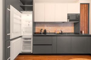 uma cozinha com armários brancos e um frigorífico aberto em Pitesti Residence em Piteşti