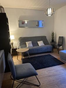 a living room with a couch and a table at Appartement de charme in Bergues
