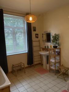 a bathroom with a sink and a table and a window at Appartement de charme in Bergues