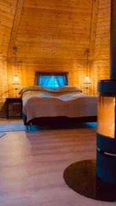ein Schlafzimmer mit einem großen Bett in einem Holzzimmer in der Unterkunft Koselig dyregård i Tromsø in Tromsø