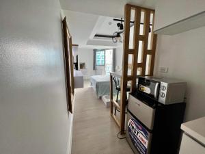 a kitchen with a room with a bed and a refrigerator at Azure North San Fernando Pampanga in San Fernando