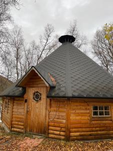 トロムソにあるKoselig dyregård i Tromsøの黒屋根の丸太小屋