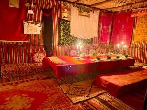 a room with a table and two beds in it at Mhamid Sahara Camp Activities - Le Chant du Sable in Mhamid +50 photos
