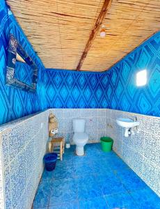 uma casa de banho em azulejos azuis com um WC e um lavatório em Mhamid Sahara Golden Dunes Camp - Chant Du Sable em Mhamid
