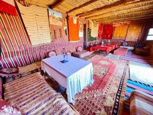 a room with a table and chairs in a room at Mhamid Sahara Camp Activities - Le Chant du Sable in Mhamid