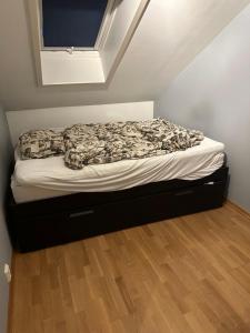 Posto letto in una piccola camera con pavimento in legno. di Old and charming penthouse a Oslo
