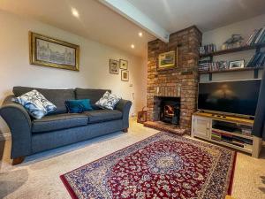 a living room with a couch and a fireplace at Well Furnished Holiday Cottage In The Heart Of Docking, Norfolk Ref 99009ht in Docking