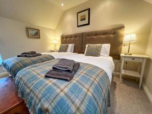 a bedroom with two beds with towels on top of them at Well Furnished Holiday Cottage In The Heart Of Docking, Norfolk Ref 99009ht in Docking