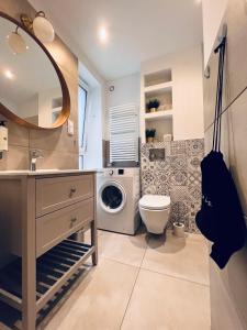 a bathroom with a sink and a washing machine at Apartamenty Żary in Żary